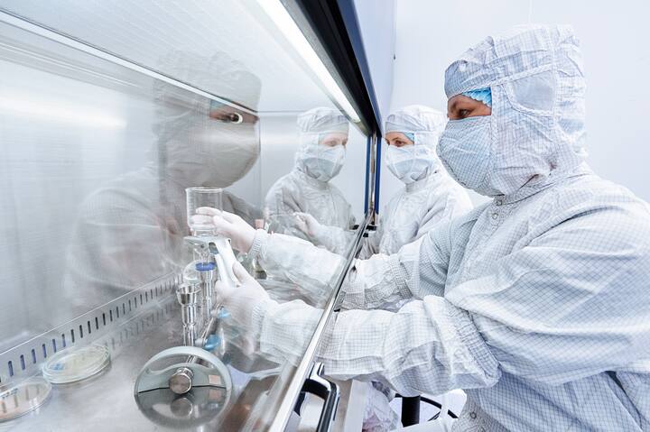 female science researchers in protective uniform and equipment works with dangerous hazard virus material at microbilogy laboratory