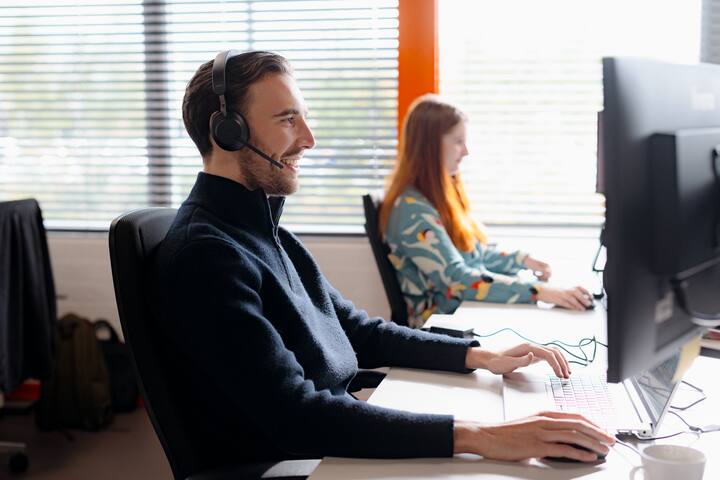 Man with headset behind computer