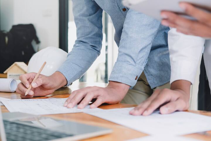 Architect or engineer working in office with blueprints,engineer inspection in workplace for architectural plan,sketching a construction project ,selective focus,Business construction concept.