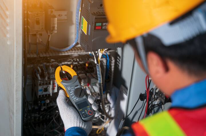 Electrician engineer tester measuring voltage and current of power electric line in electical cabinet control.Electrician use Digital Voltmeter Testing Voltage on automatic control box.Selective focus