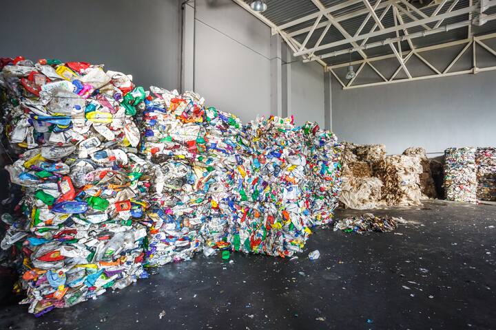 Plastic bales of rubbish at the waste treatment processing plant. Recycling separatee and storage of garbage for further disposal, trash sorting. Business for sorting and processing of waste.