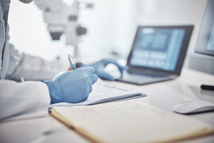Science, research and hands in lab with notebook and computer on scientific analysis. Experiment, internet and analytics, scientist in laboratory with data, vision and future in medical innovation
