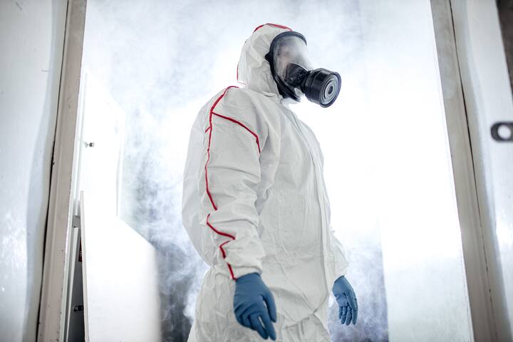 professional disinfector in protective suit holding chemical sprayer and other equipment for sterilization and decontamination of viruses, infectious diseases. coronavirus, COVID-19 epidemic concept