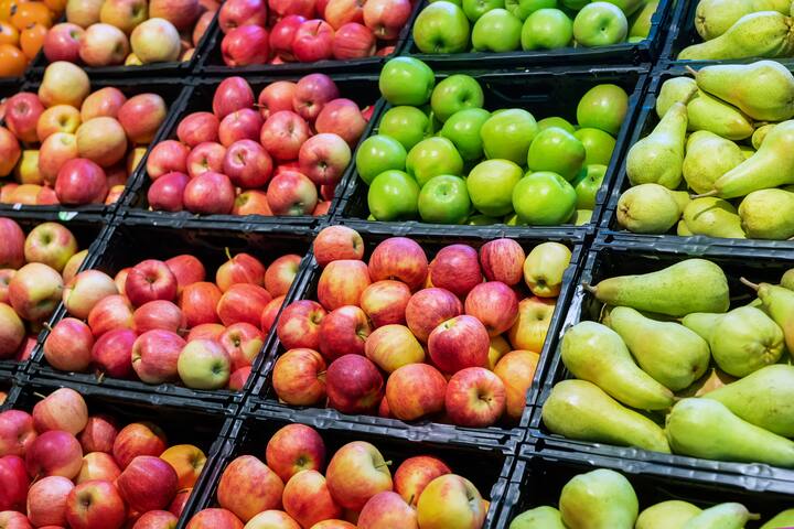 Grocery supermarket store. Shelves with variety of different orgnaic fresh ripe pears and apples. Vegetable and fruit market.