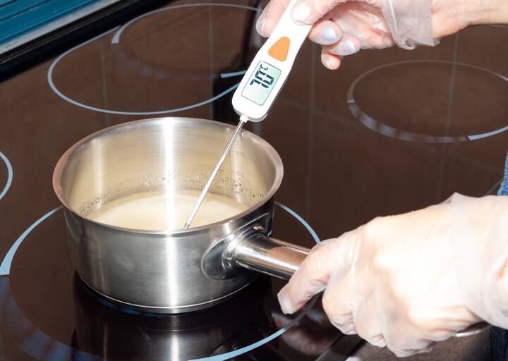 The temperature of the boiling syrup in the pan is measured with an electronic thermometer.