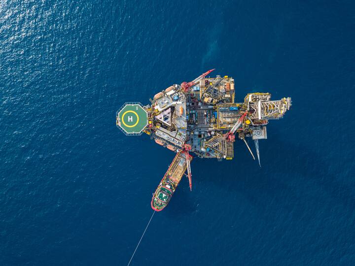 Aerial view from a drone of an offshore jack up rig at the offshore location with a supply boat