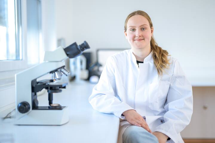 Woman smiling with microscope