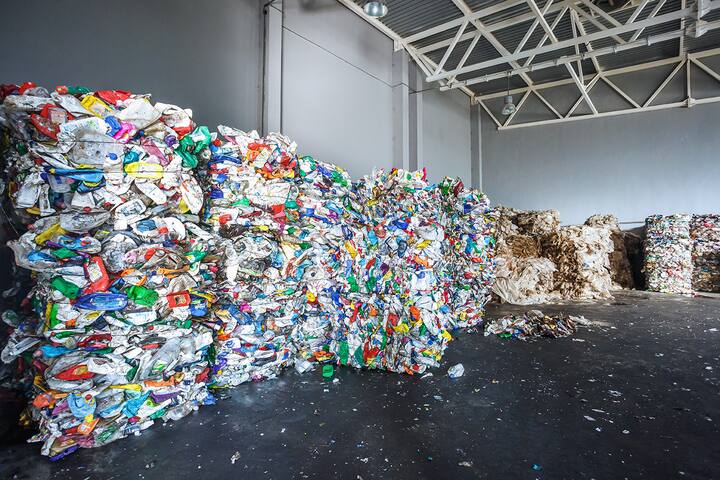 Plastic bales of rubbish at the waste treatment processing plant. Recycling separatee and storage of garbage for further disposal, trash sorting. Business for sorting and processing of waste.